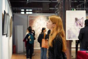Eine internationale Besucherin betrachtet eines der ausgestellten Kunstwerke. © Fuling Cultural Center